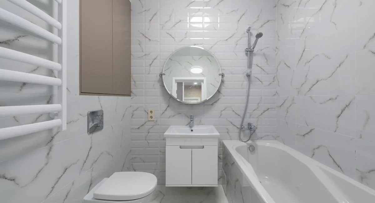 Salle de bain moderne avec grandes plaques de carrelage grès cérame gris clair au mur