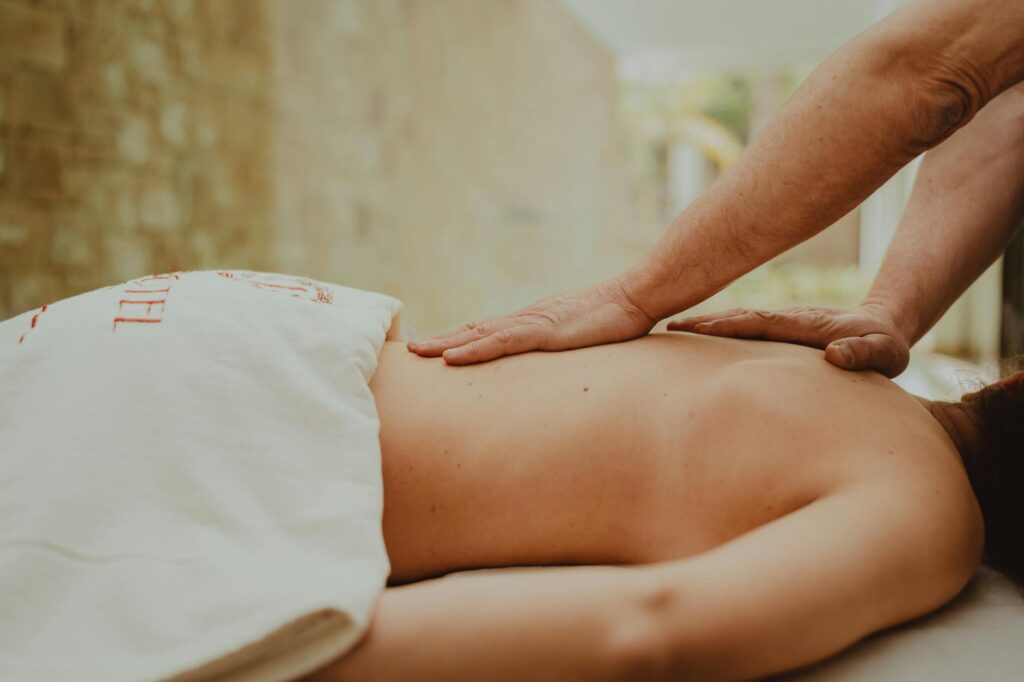 Masseuse praticienne effectuant un massage bien-être relaxant sur table de soin