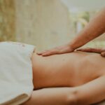 Masseuse praticienne effectuant un massage bien-être relaxant sur table de soin