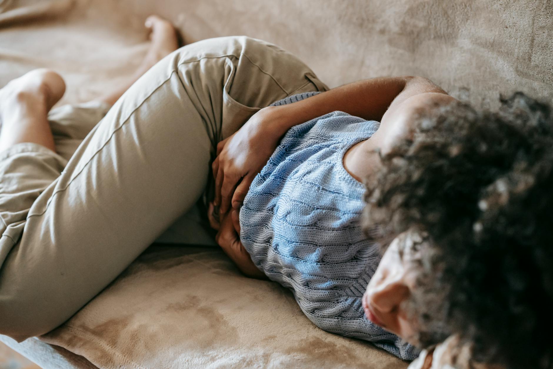 femme allongée tenant son ventre douloureux sans règles apparentes