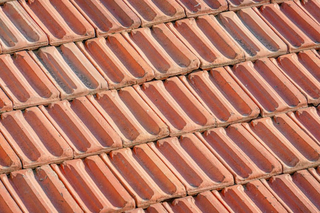 Vue rapprochée de tuiles mécaniques en terre cuite sur une toiture en pente