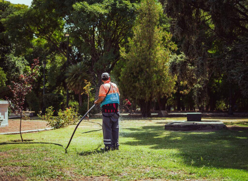 Pulvérisateur de jardin posé sur sol avec désherbant et mauvaises herbes