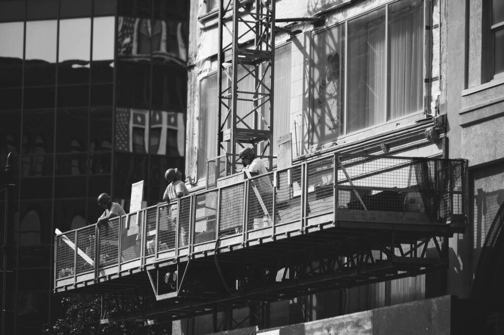 Façade de maison en cours de ravalement avec échafaudage et ouvrier