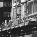 Façade de maison en cours de ravalement avec échafaudage et ouvrier