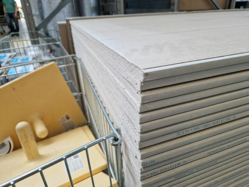 Artisan appliquant un enduit lissé sur un mur intérieur blanc