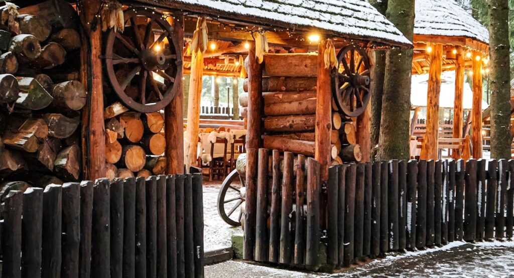 Abri cuisine d'été en bois avec barbecue et plan de travail extérieur dans un jardin verdoyant