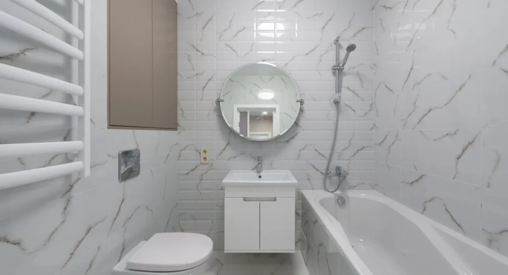 Salle de bain moderne avec grandes plaques de carrelage grès cérame gris clair au mur