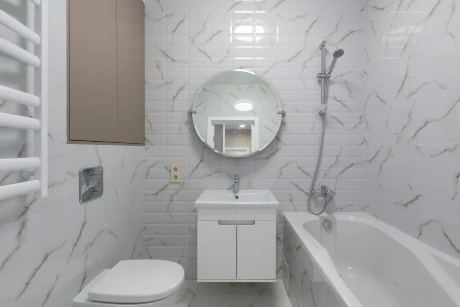 Salle de bain moderne avec grandes plaques de carrelage grès cérame gris clair au mur