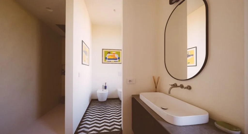 Salle de bains rénovée avec panneaux muraux blancs effet marbre et douche italienne