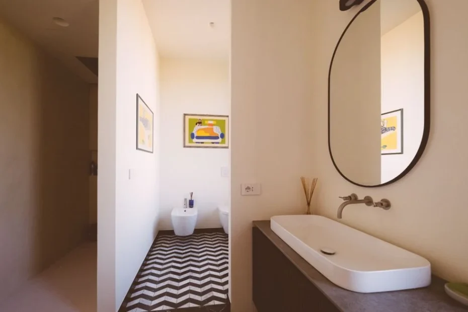 Salle de bains rénovée avec panneaux muraux blancs effet marbre et douche italienne