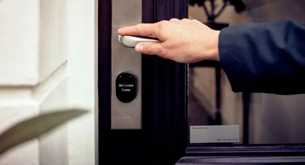 Une main ferme referme une porte d’entrée munie de 5 points automatiques
